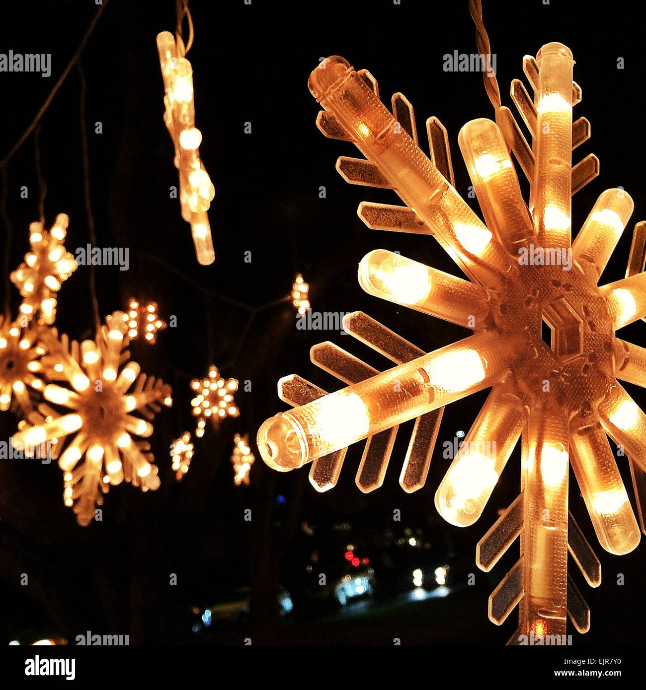 Nahaufnahme von Lichtern beleuchtete Schneeflocke - Smartphone-aufgenommenes Stockfoto