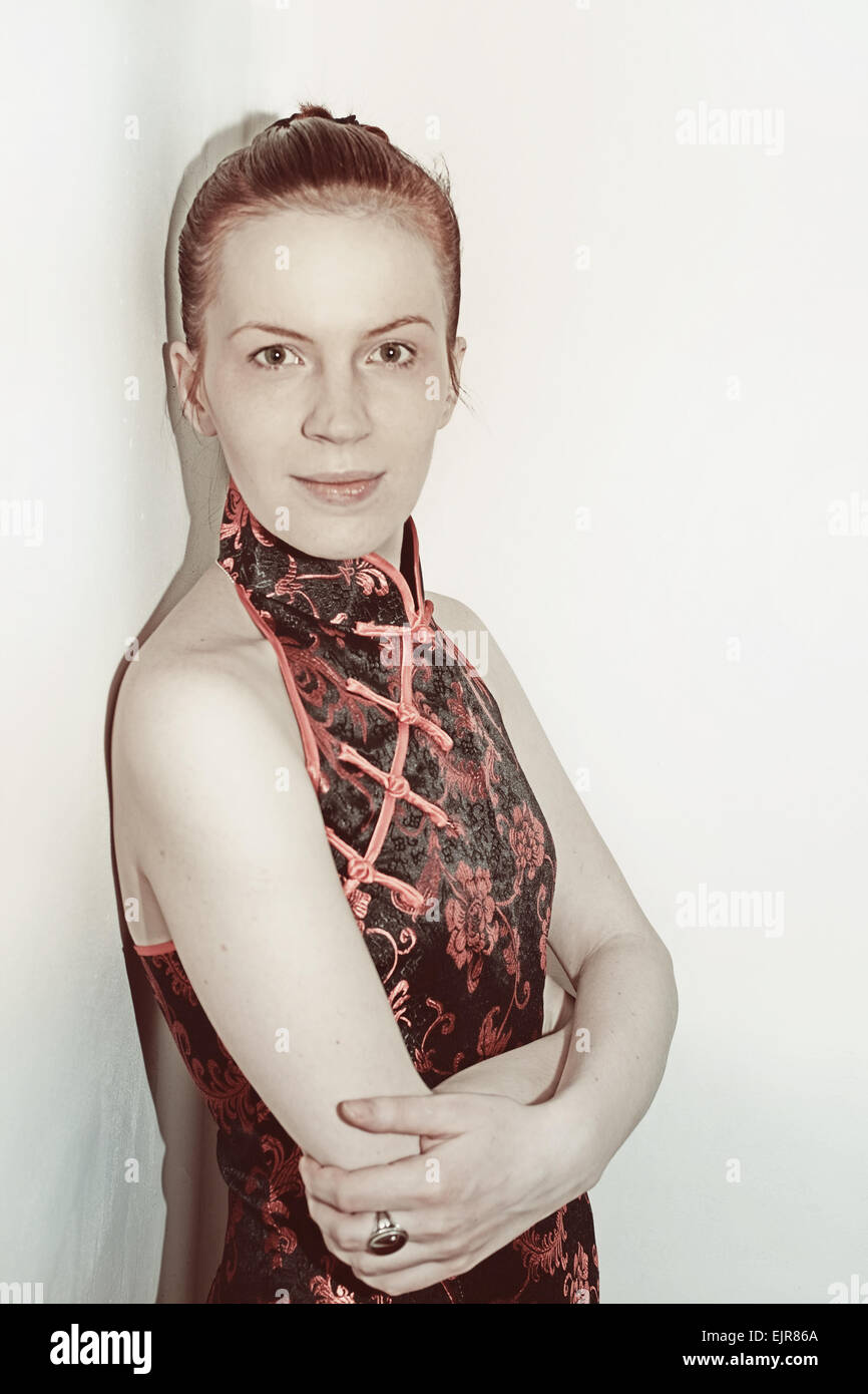 Schöne Frau in einem japanischen Kleid auf einem Stuhl sitzend Stockfoto