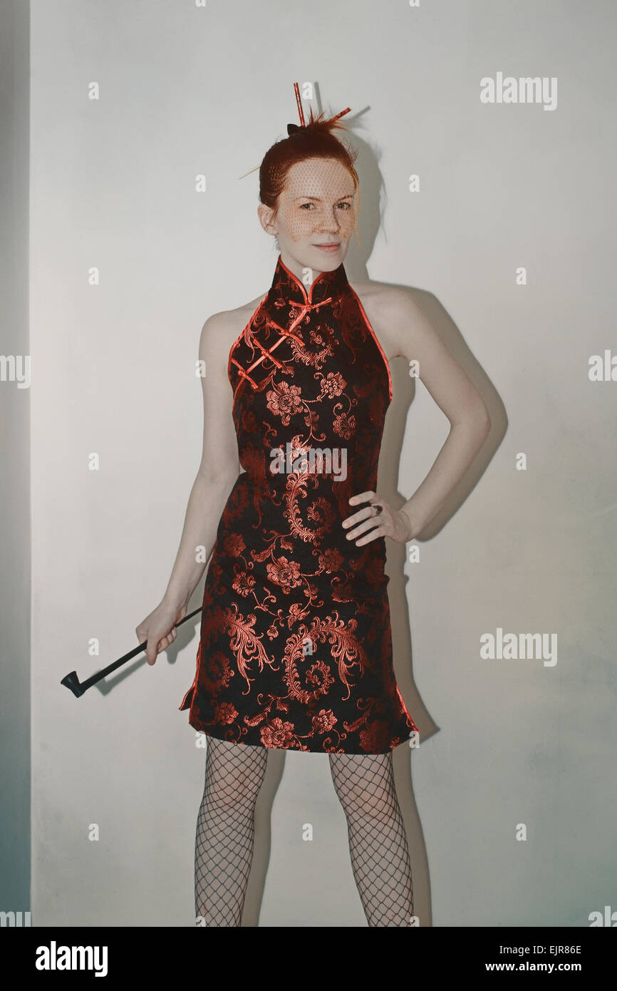 Porträt einer jungen Frau in einem japanischen Kleid und Schleier mit einem Rohr Stockfoto