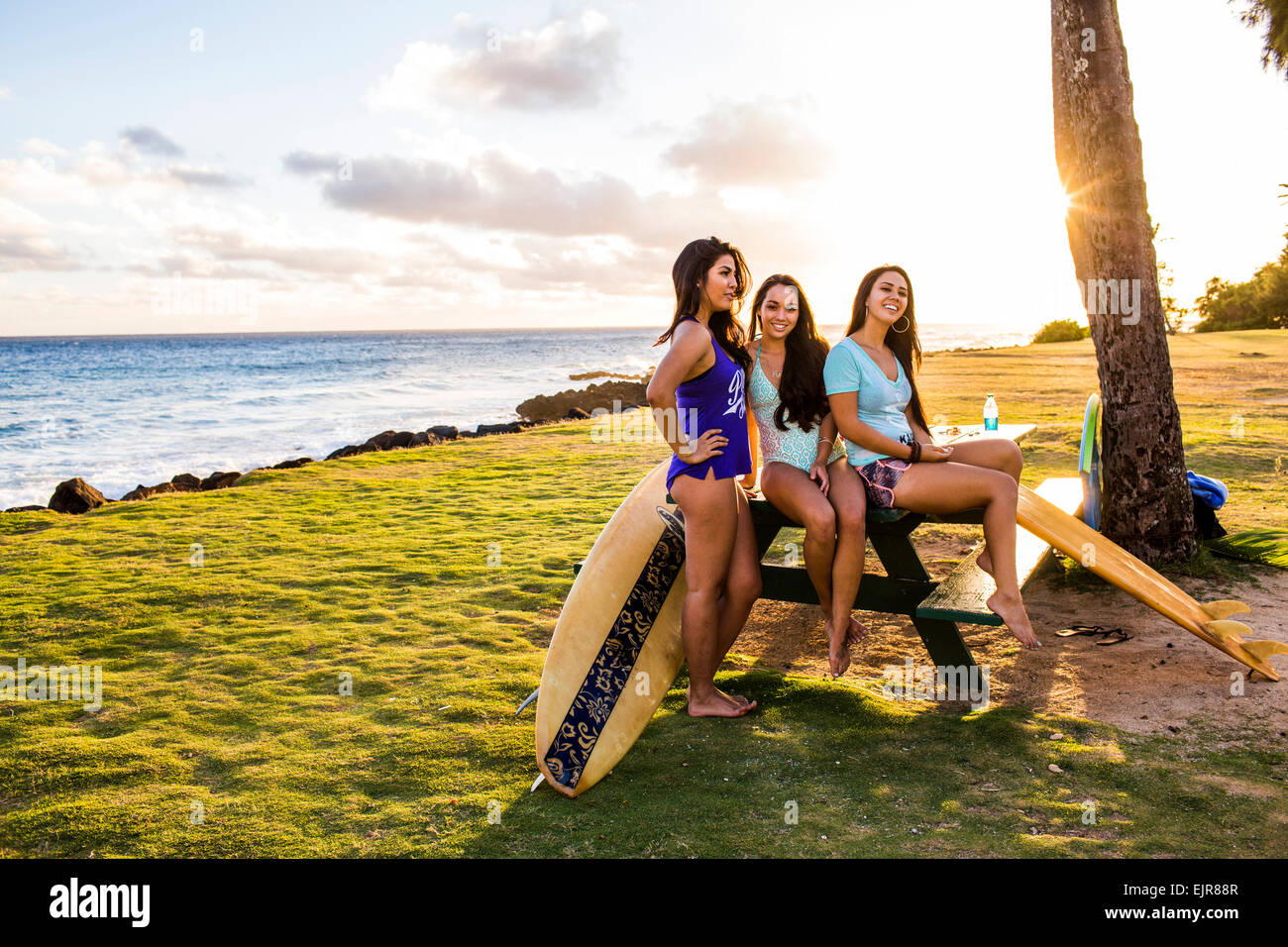Pacific Islander Frauen Lächeln auf Picknick-Tisch in der Nähe von Strand Stockfoto
