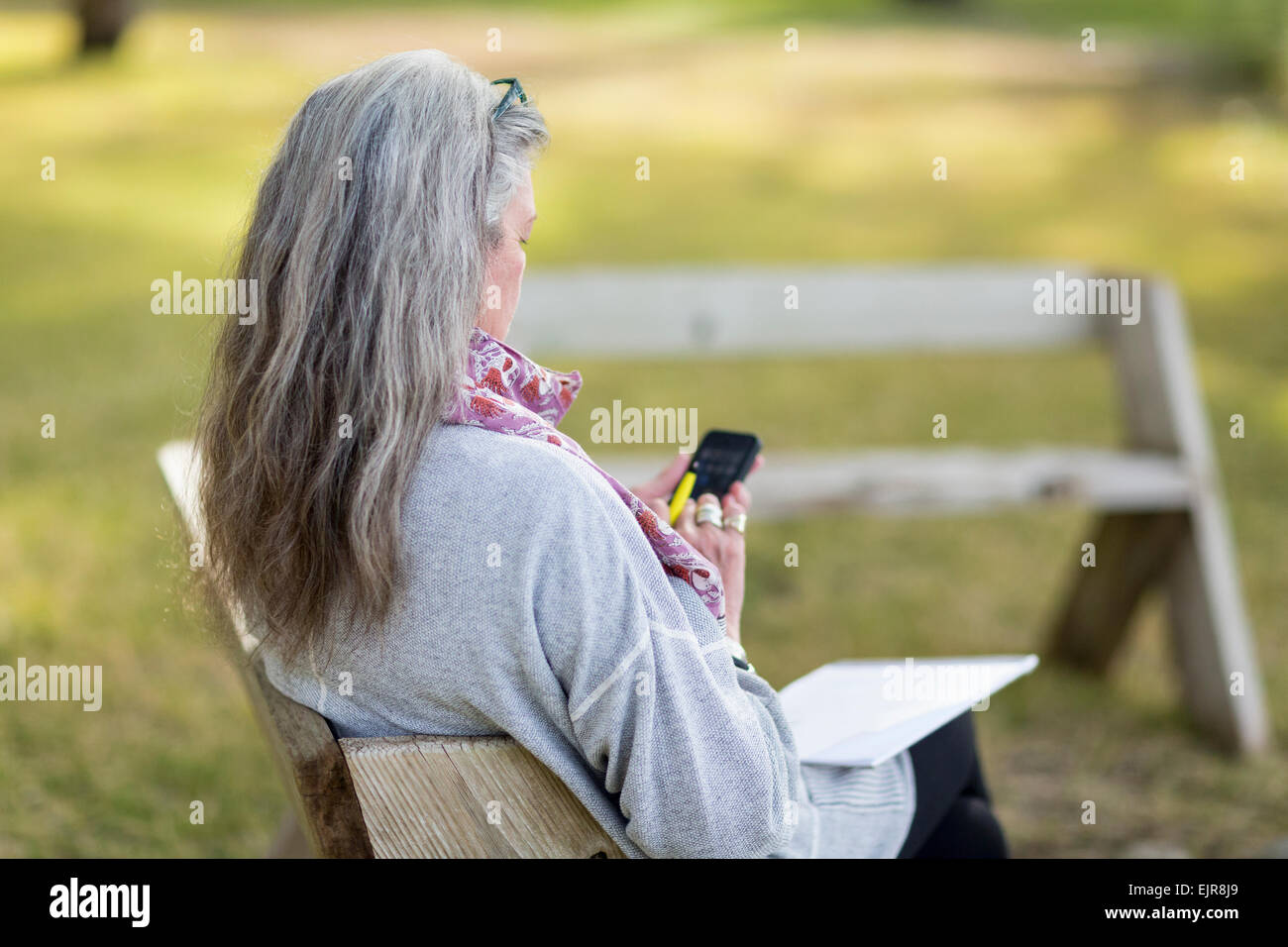 Ältere Frau kaukasischen mit Handy im freien Stockfoto