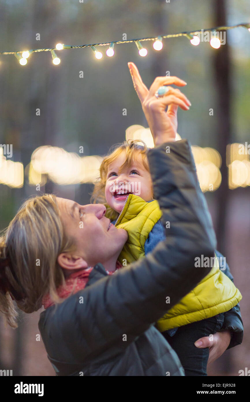 Kaukasische Mutter und Sohn bewundern Lichterketten Stockfoto