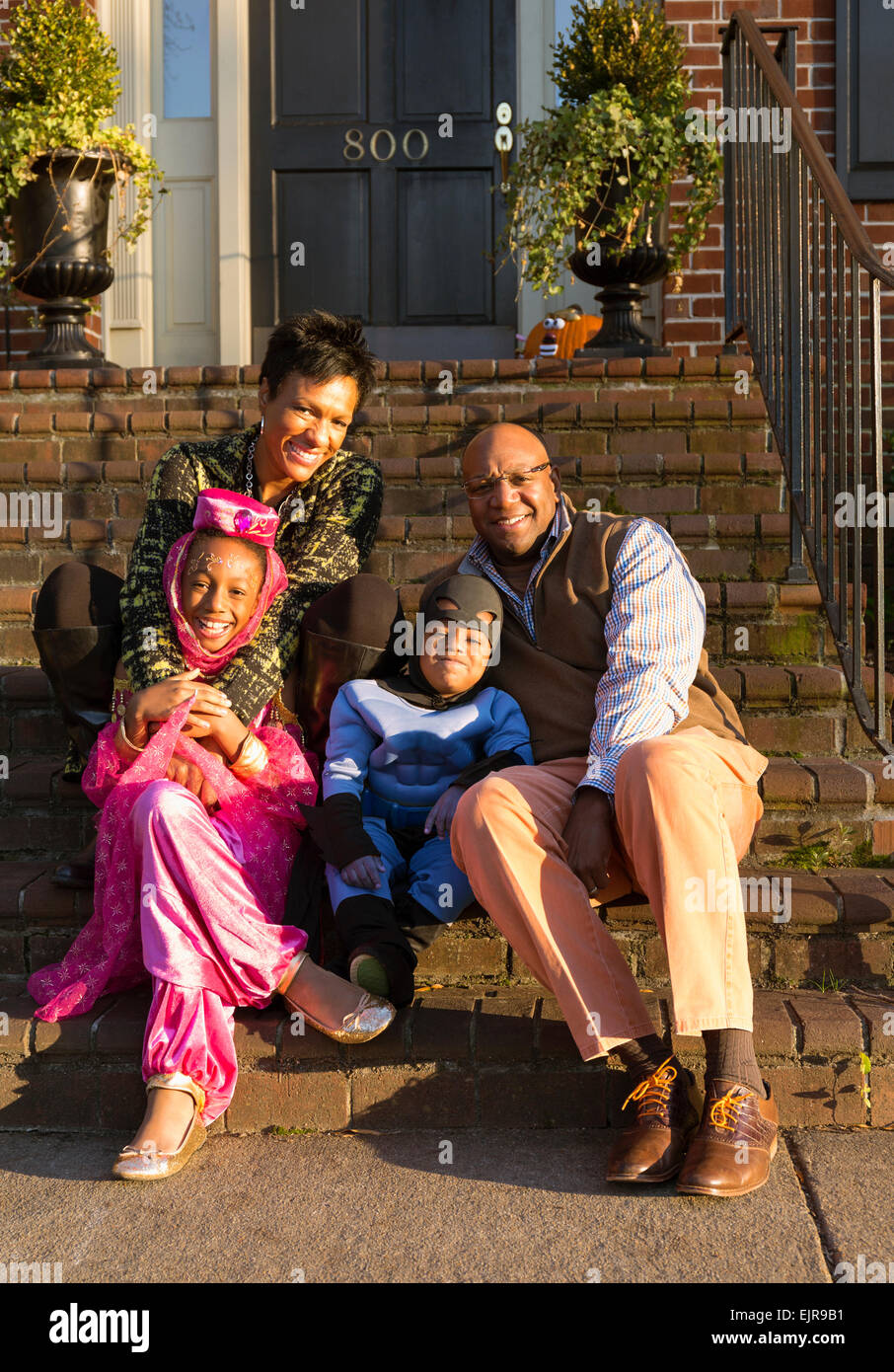 Afrikanische amerikanische Eltern lächelnd mit Kinder in Halloween-Kostümen Stockfoto