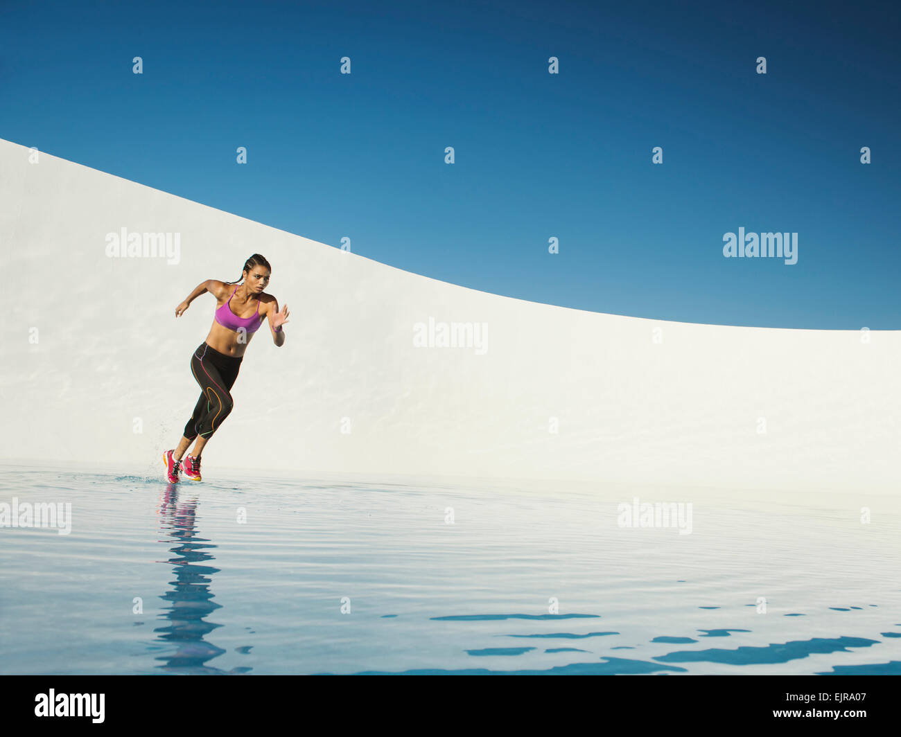Gemischte Rassen Frau läuft auf Wasseroberfläche Stockfoto