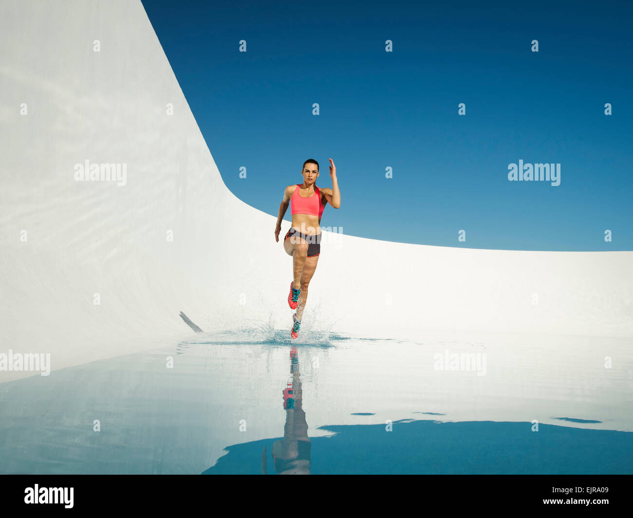 Kaukasische Frau läuft auf Wasseroberfläche Stockfoto