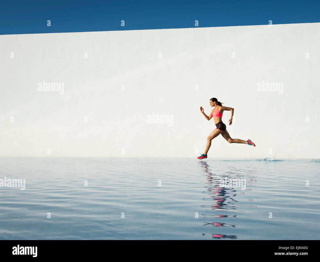 Kaukasische Frau läuft auf Wasseroberfläche Stockfoto