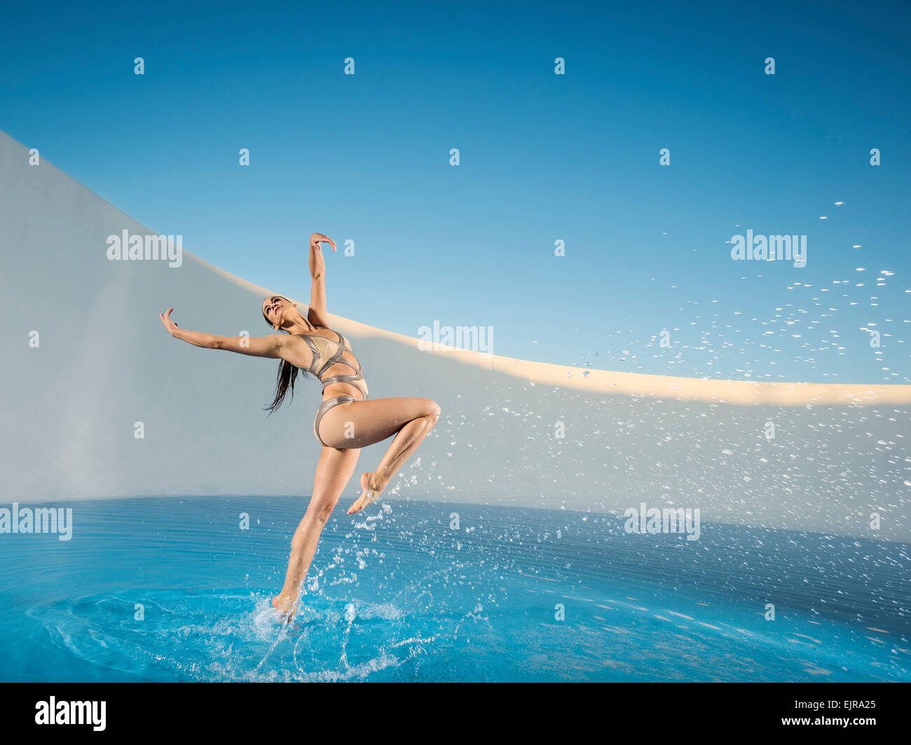Kaukasische Frau tanzt am Schwimmbad Stockfoto