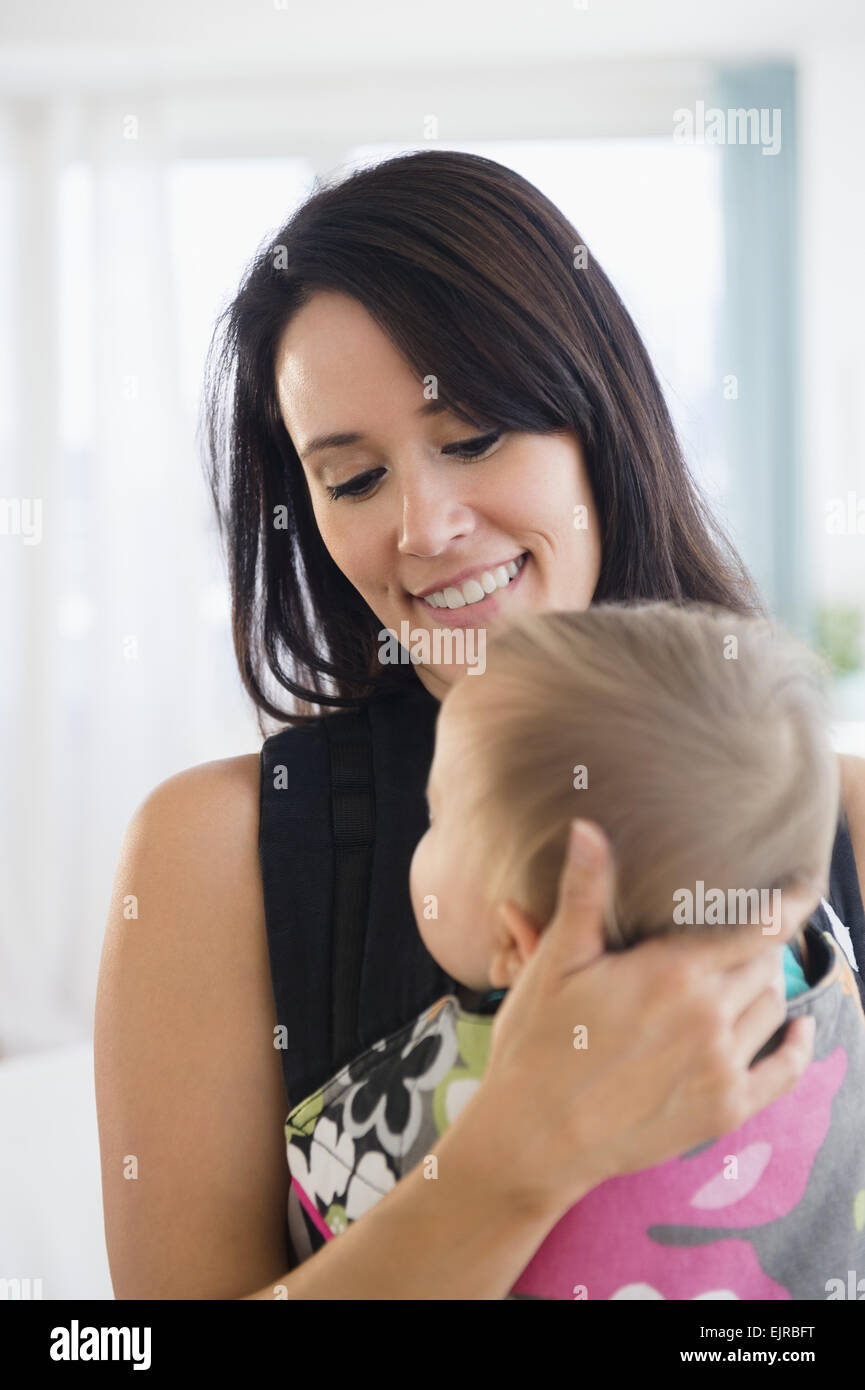 Mischlinge Mutter halten Baby im Tragetuch Stockfoto