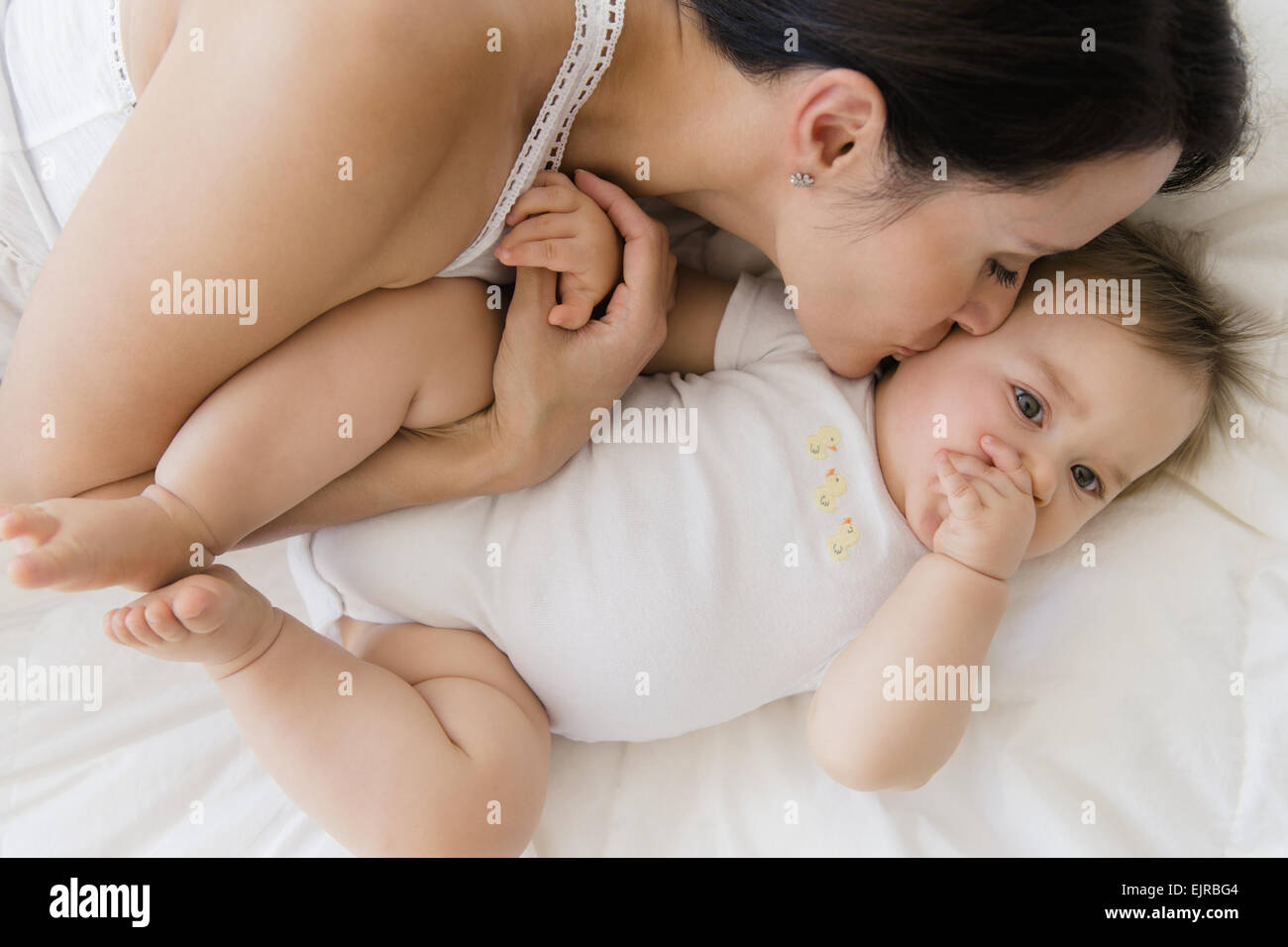 Draufsicht der Mischlinge Mutter küssen Baby auf Bett Stockfoto