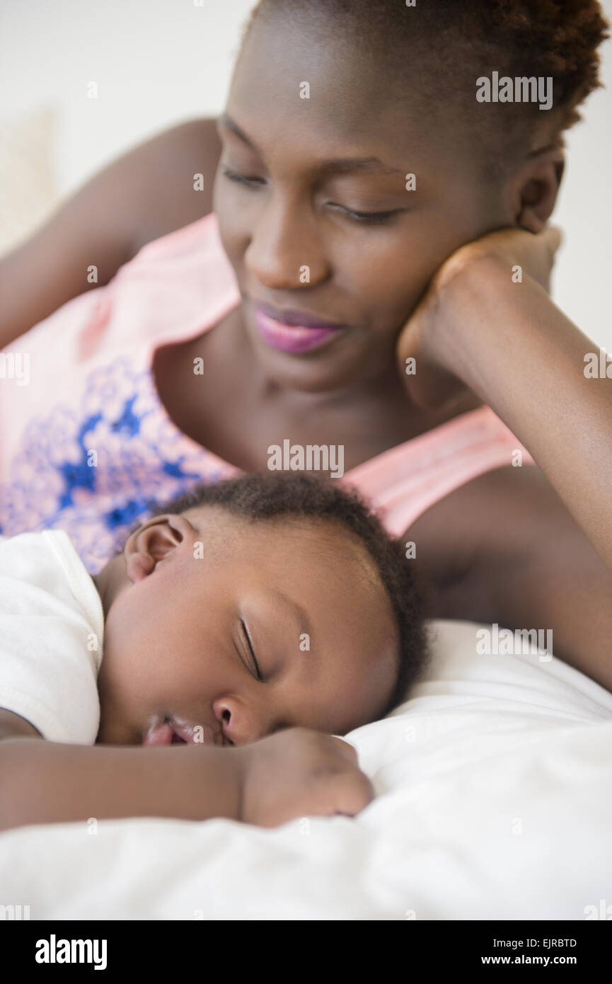 Schwarze Mutter bewundernden schlafenden Sohn auf Bett Stockfoto