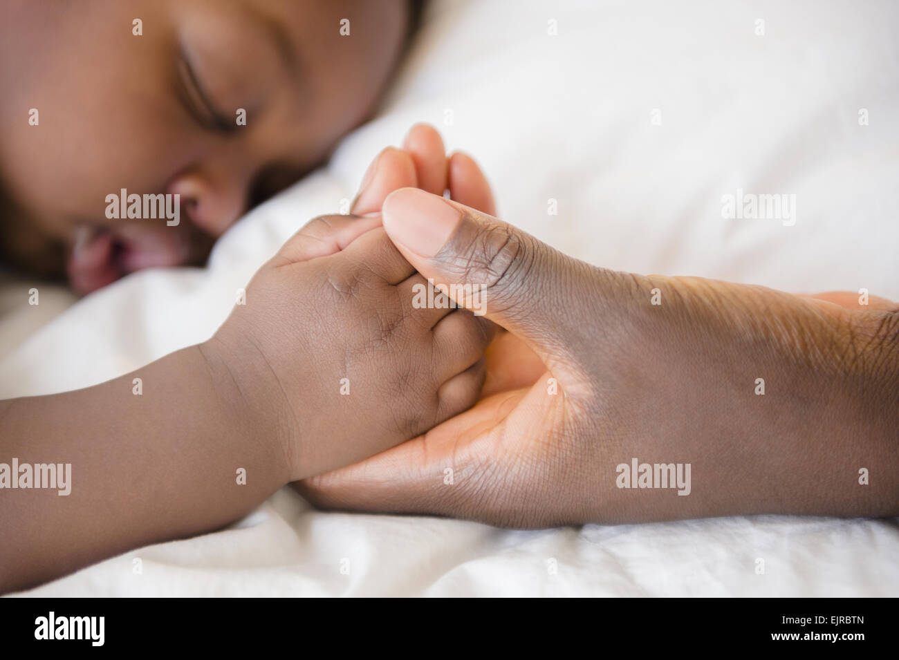 Nahaufnahme von schwarzen Mutter an Hand der schlafenden baby Stockfoto