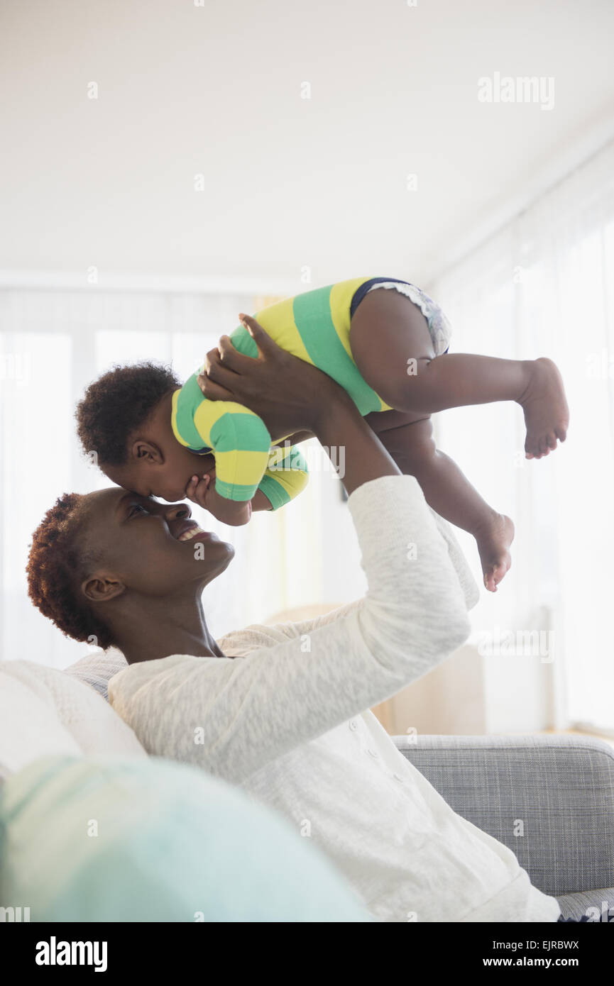 Schwarze Mutter spielen mit Baby junge auf sofa Stockfoto