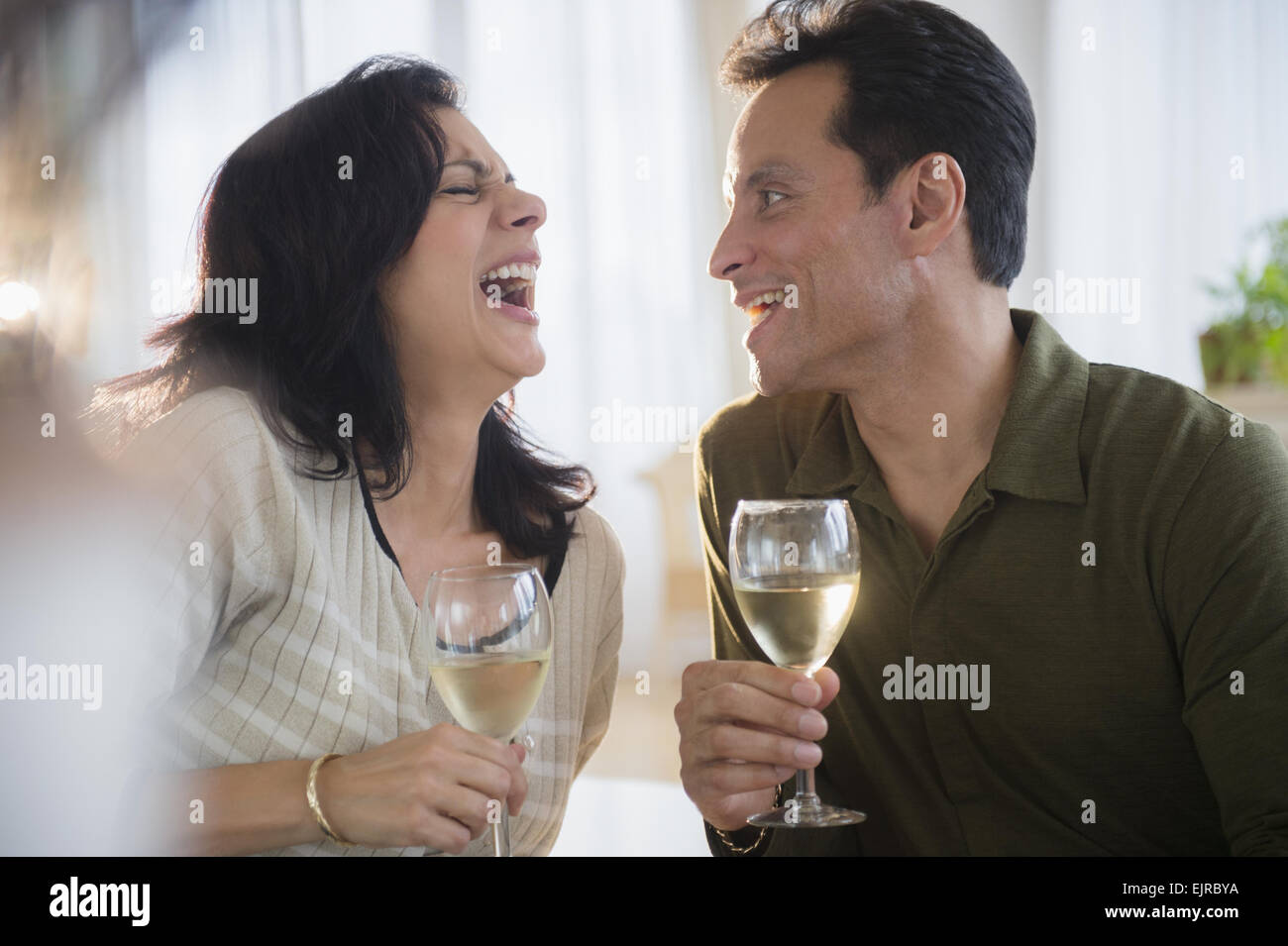 Paar, lachen und trinken Weißwein Stockfoto