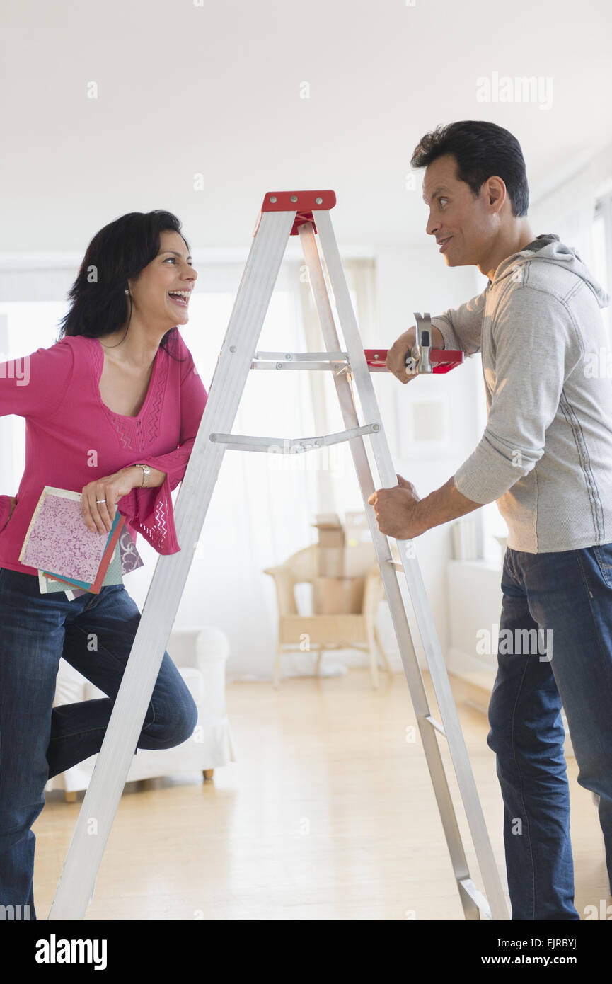 Paar sprechen auf Leiter im Hause Umbau Stockfoto