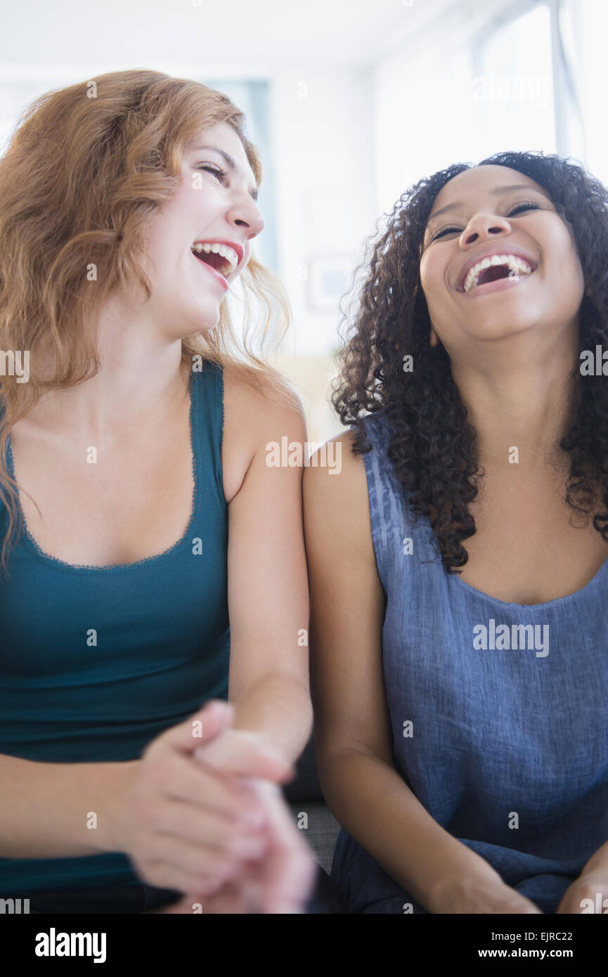 Frauen lachen auf sofa Stockfoto