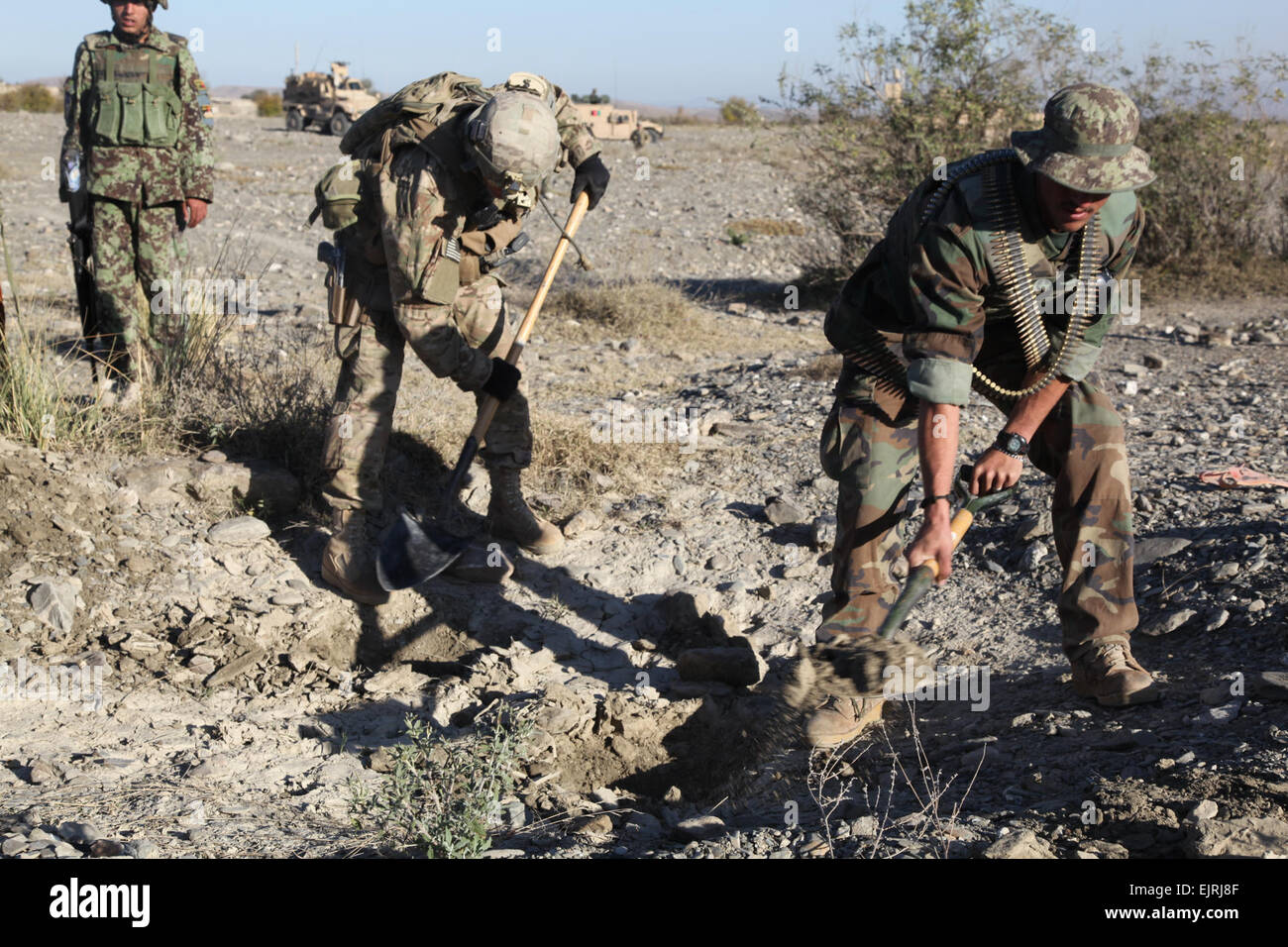 US Armee Sgt. Nathan West, links, aus Minneapolis, Mo., serviert mit C Truppe, 6. Squadron, 4. Kalvarienberg Regiment, 1st Infantry Division 3rd Brigade Combat Team, Task Force Duke und ein Afghan National Army Soldat, suchen eine mögliche Waffenlager, 29. November 2011, außerhalb Camp Parsa, Khowst Provinz, Afghanistan. Machen sich eine ständige Präsenz, Kräfte USA und die afghanische arbeiten, stellen sich die Einheimischen und Aufständischen Aktivität zu entmutigen. Stockfoto