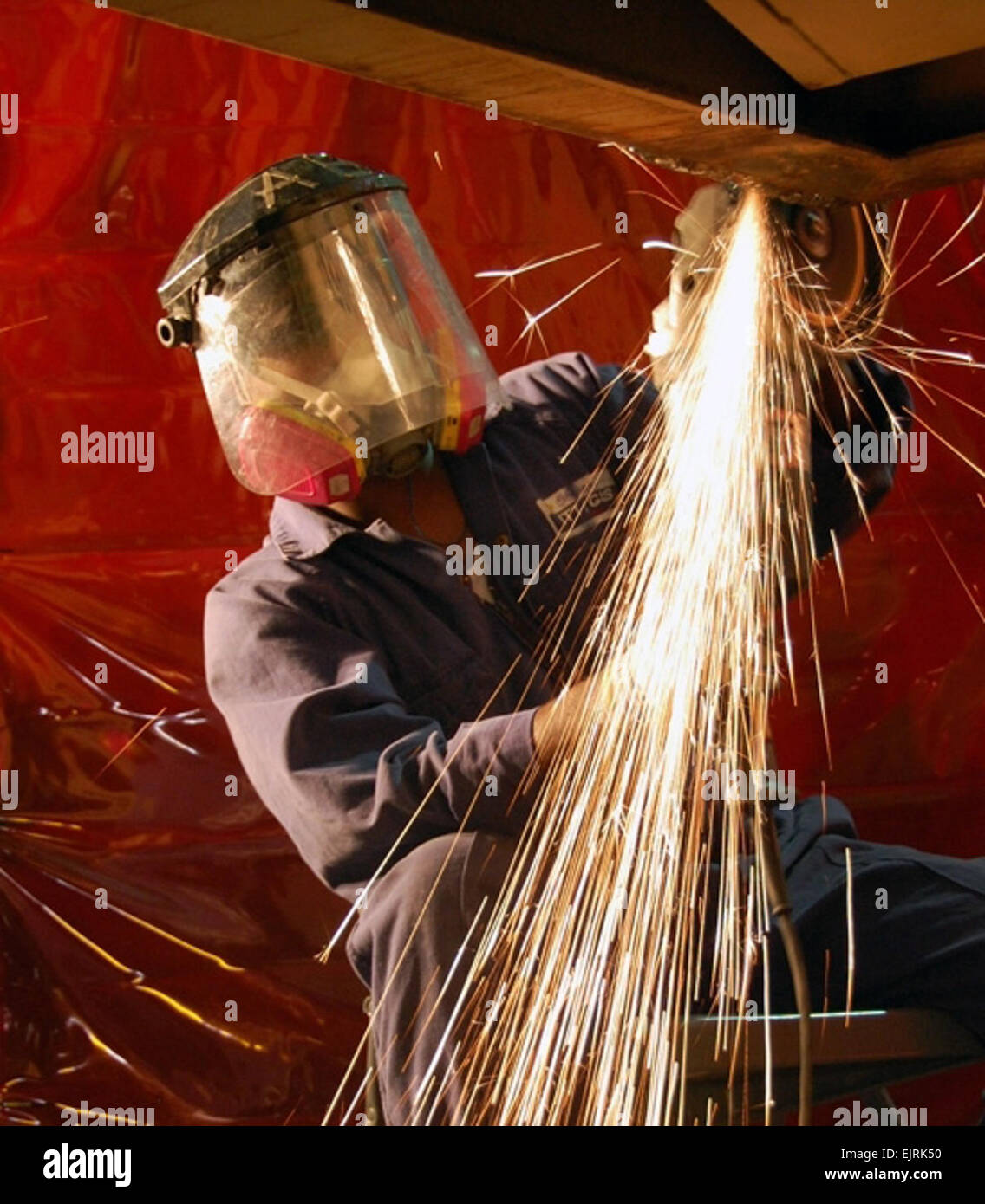 Frühe Feuerwerk Jim Hinnant, 401. Army Field Support Brigade 1. Juli 2008 Senaka Sriweera, Angestellter ITT Corp. aus Sri Lanka, schafft eine Anzeige von Funken, wie er entfernt grobe Metall aus dem Körper der Raupe 621B Schaber, 29. Juni, 1. Bataillon, 401. Armee Feld Support Brigade Auto Körper Reparaturwerkstatt im Camp als Sayliyah, Qatar schleift. Stockfoto