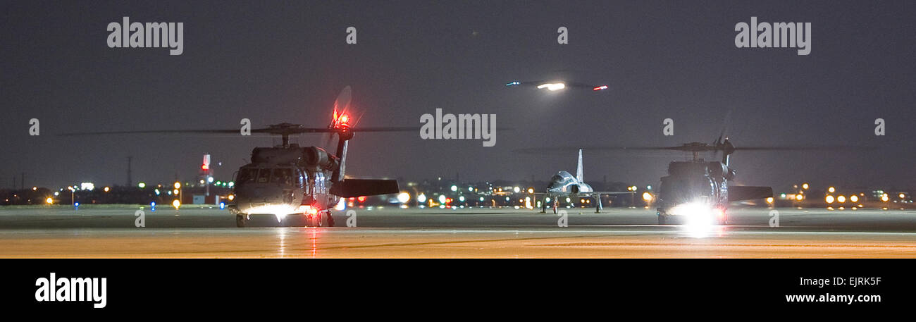 Black Hawk-Hubschrauber aus Texas Army National Guard warten mit ihren Motoren als die c-17 Globemaster III Flugzeug mit drei ehemaligen Geiseln Ansätze Lackland Air Force Base, Texas, 2. Juli 2008 ausgeführt. Drei US-Regierung Fremdfirmen wurden heute durch die kolumbianischen Sicherheitskräfte gerettet, nachdem da ihr Flugzeug abgestürzt ist in einer abgelegenen Gegend im Februar 2003 durch die Revolutionäre bewaffnete Kräfte von Kolumbien oder FARC, gefangen gehalten. Das Flugzeug ist in Travis Air Force Base, Kalifornien stationiert.  Lance Cheung Stockfoto