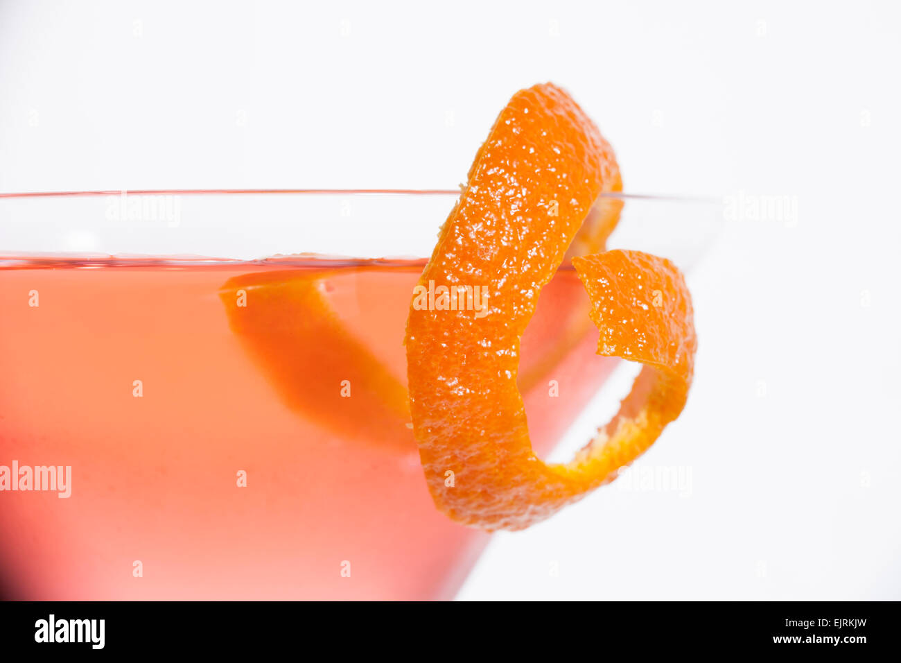 Ein Martini-Glas ist mit einem rosa cosmopolitan Cocktail mit einem Stück orange garnieren am Rand gefüllt; Querformat, weiß Stockfoto