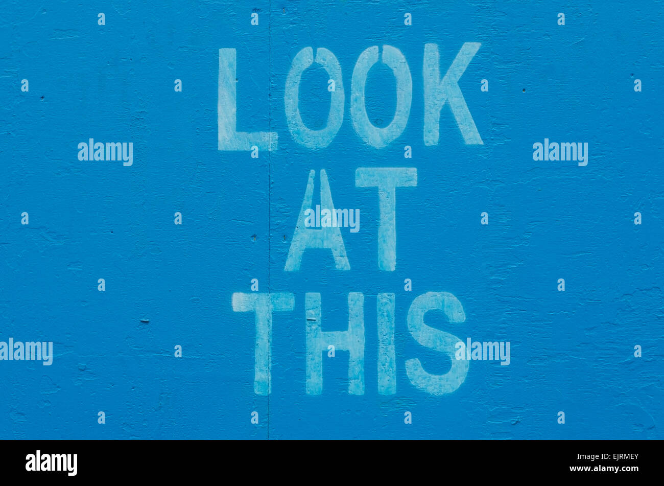 Blau lackierten hölzernen Hintergrund mit dem Satz "schauen Sie sich diese" von Schablone gedruckt Stockfoto