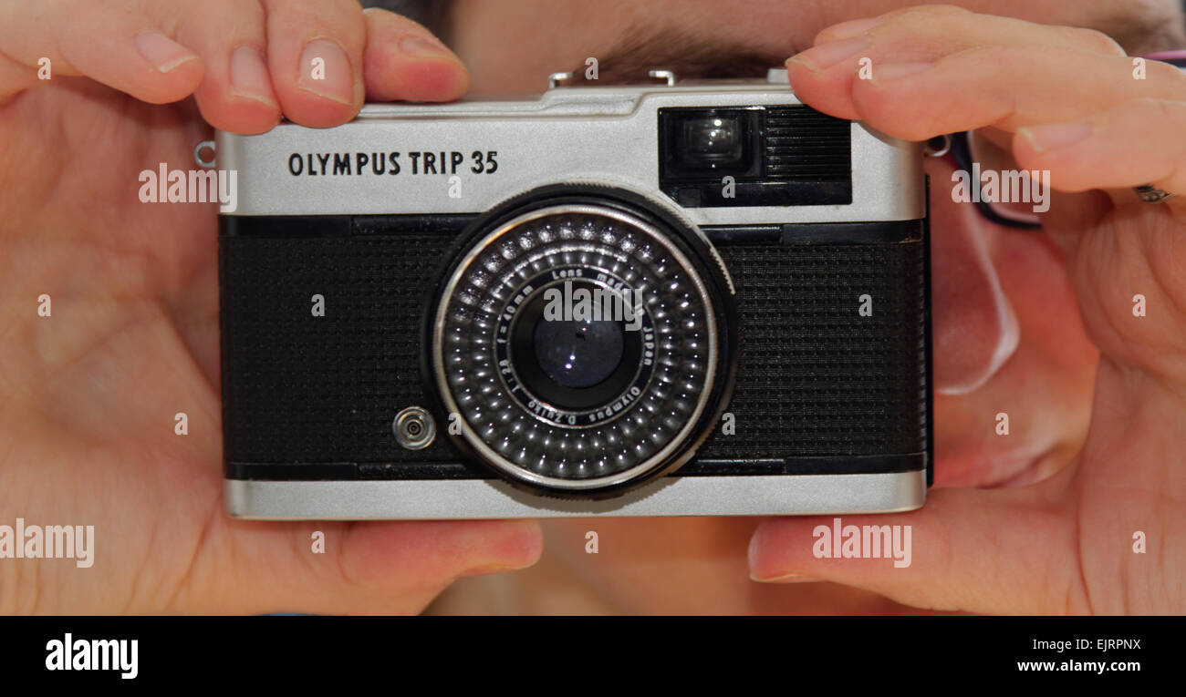 Eine Frau, die den klassischen Olympus Trip 35 kompakte Kamera Stockfoto