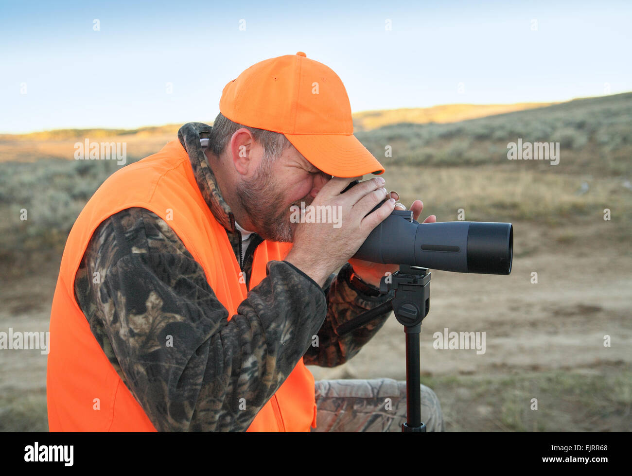Hunter trägt Orange und Durchsicht Spektiv Stockfoto