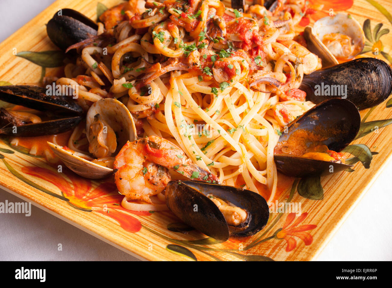 Eine bunte Platte hält Meeresfrüchte Fra Diavolo über Linguine. Stockfoto