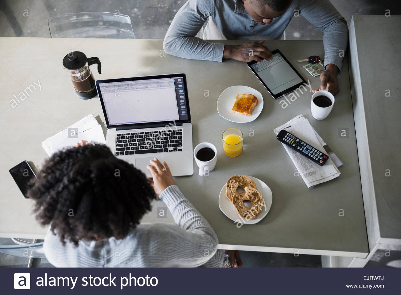 Draufsicht eines Paares mit Technologie in Küche Stockfoto