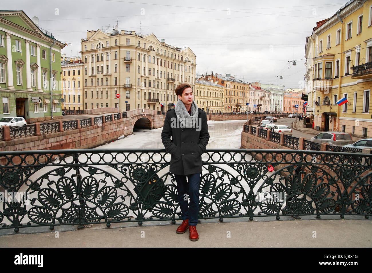 Junger Mann posiert in der Moyka Bahndamm in der Hintergrund-Architektur, St. Petersburg Stockfoto