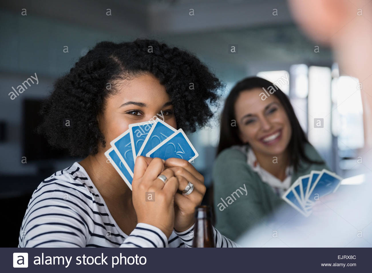 Frau versteckt sich hinter Spielkarten Stockfoto