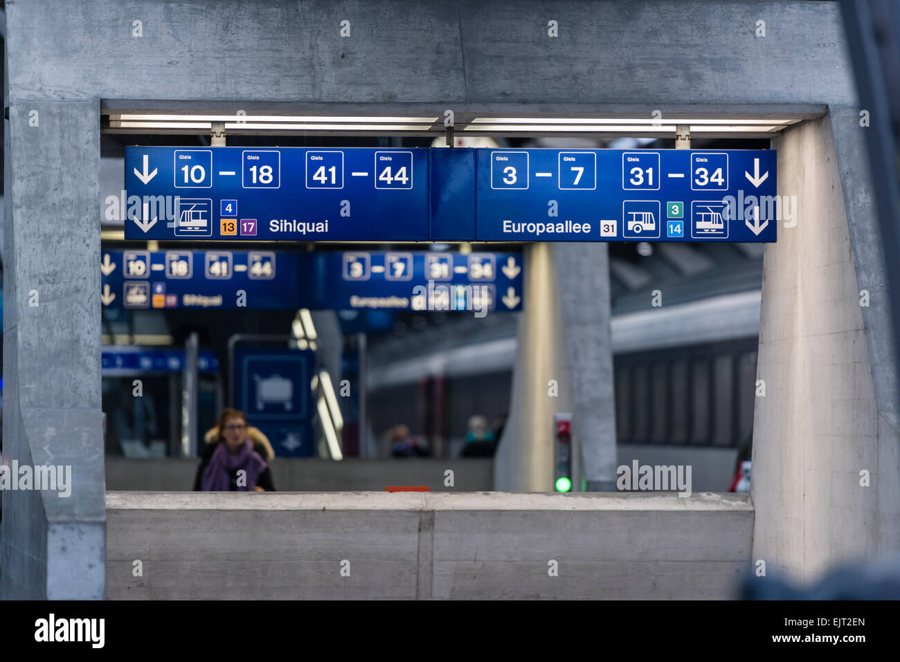 Wegweiser führen und Reisende auf den Plattformen der Zürcher Hauptbahnhof informieren. Stockfoto