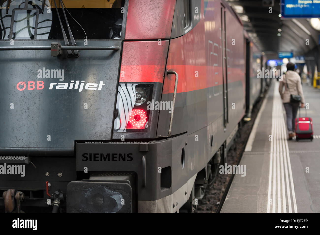 Ein Reisender ist Fuß von einem österreichischen ÖBB Railjet intercity Zug, der auf einer Plattform am Hauptbahnhof Zürich (Schweiz) wartet. Stockfoto
