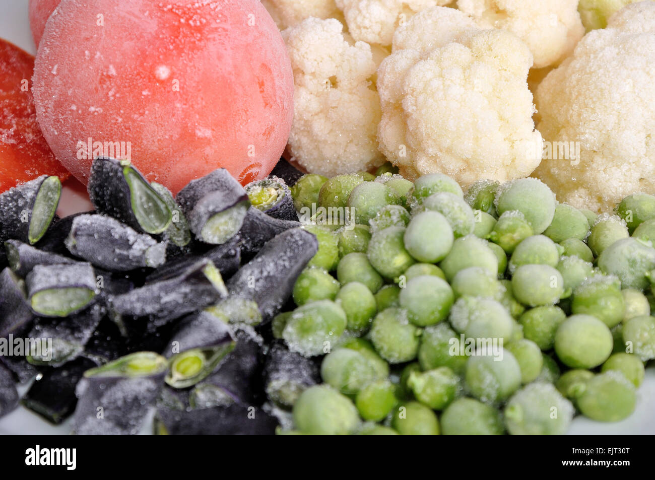 Haufen von eingefrorenen Tomaten, Spargel, Erbsen und Blumenkohl Stockfoto