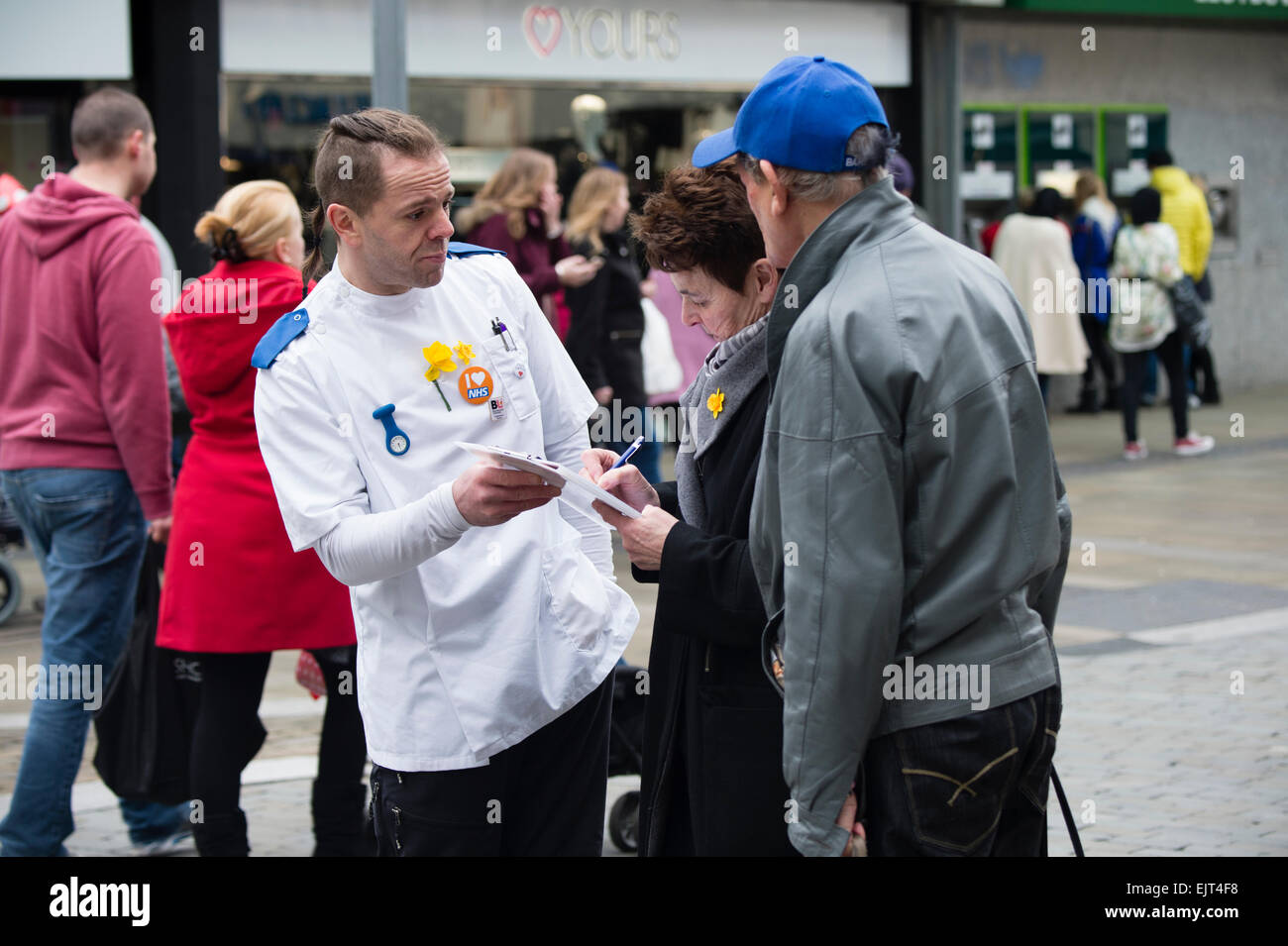 Einem nationalen Gesundheitsdienst NHS Arbeiter Krankenpfleger in medizinischen Uniform, sammeln von Unterschriften auf eine Petition gegen die Kürzungen für die Erbringung von Gesundheitsversorgung, Swansea Stadtzentrum, Wales UK Stockfoto