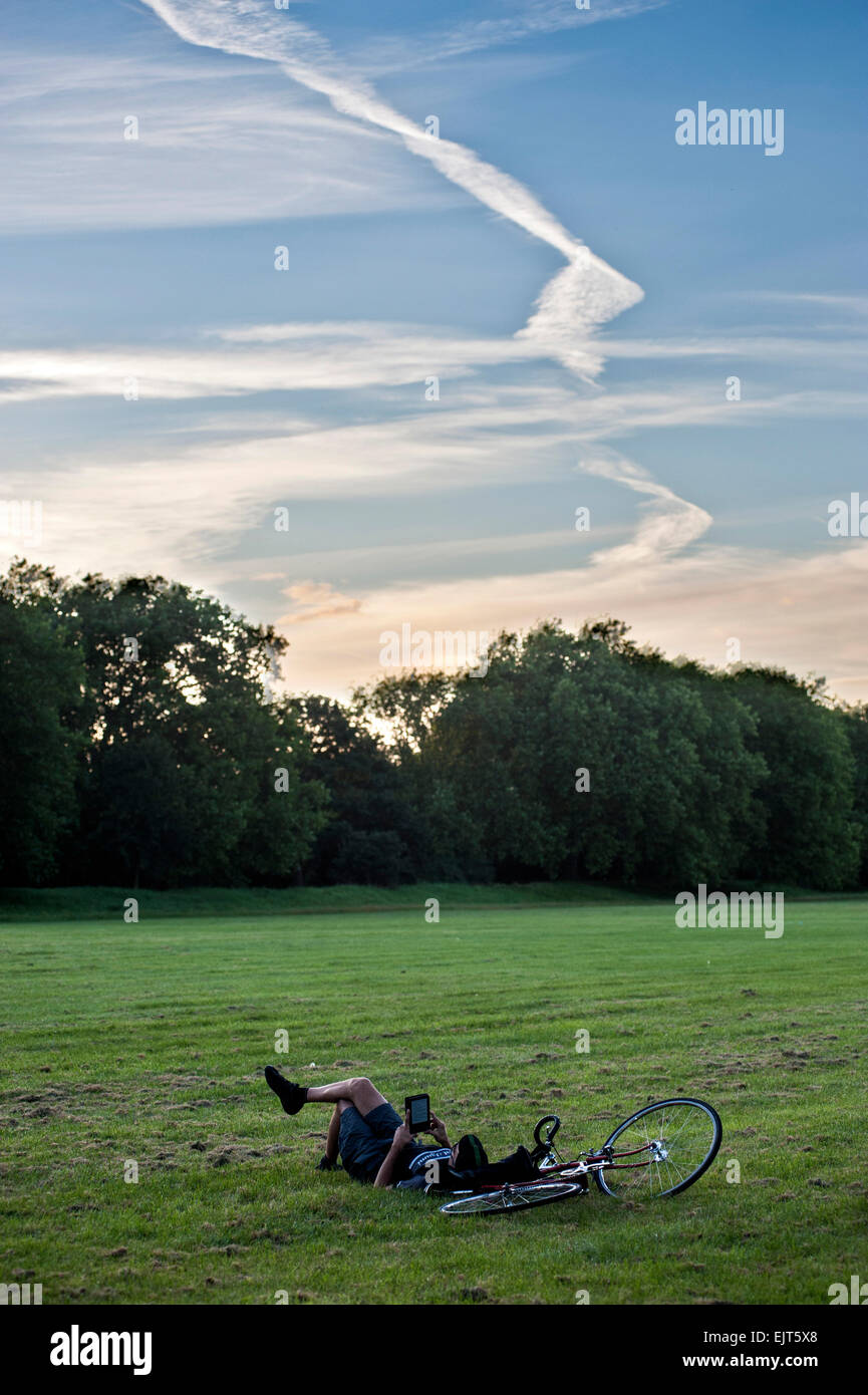 Ein Teenager sein Bike parks und liest seine tablet Stockfoto