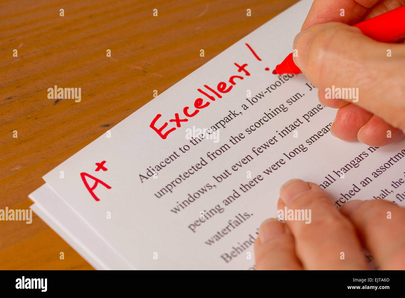 Hand mit roten Stift Verschneidung Papiere mit hervorragend - Erfolgskonzept im Bildungssektor Stockfoto