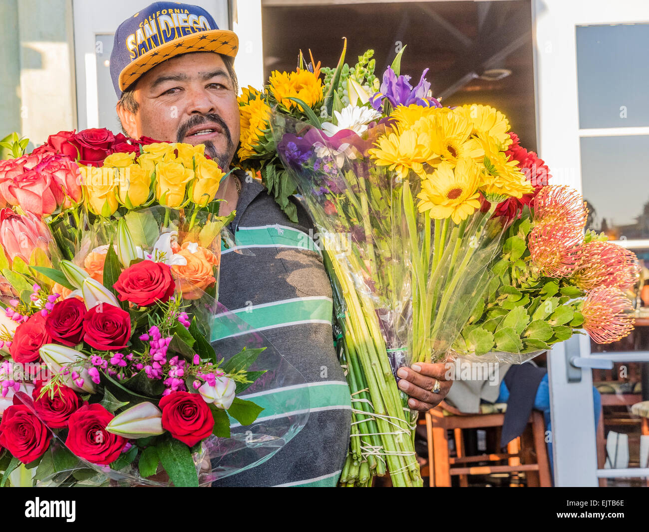 Ein Hispanic Mann mittleren Alters hausieren Blumen in einem Restaurant in Capitola, CA. Stockfoto