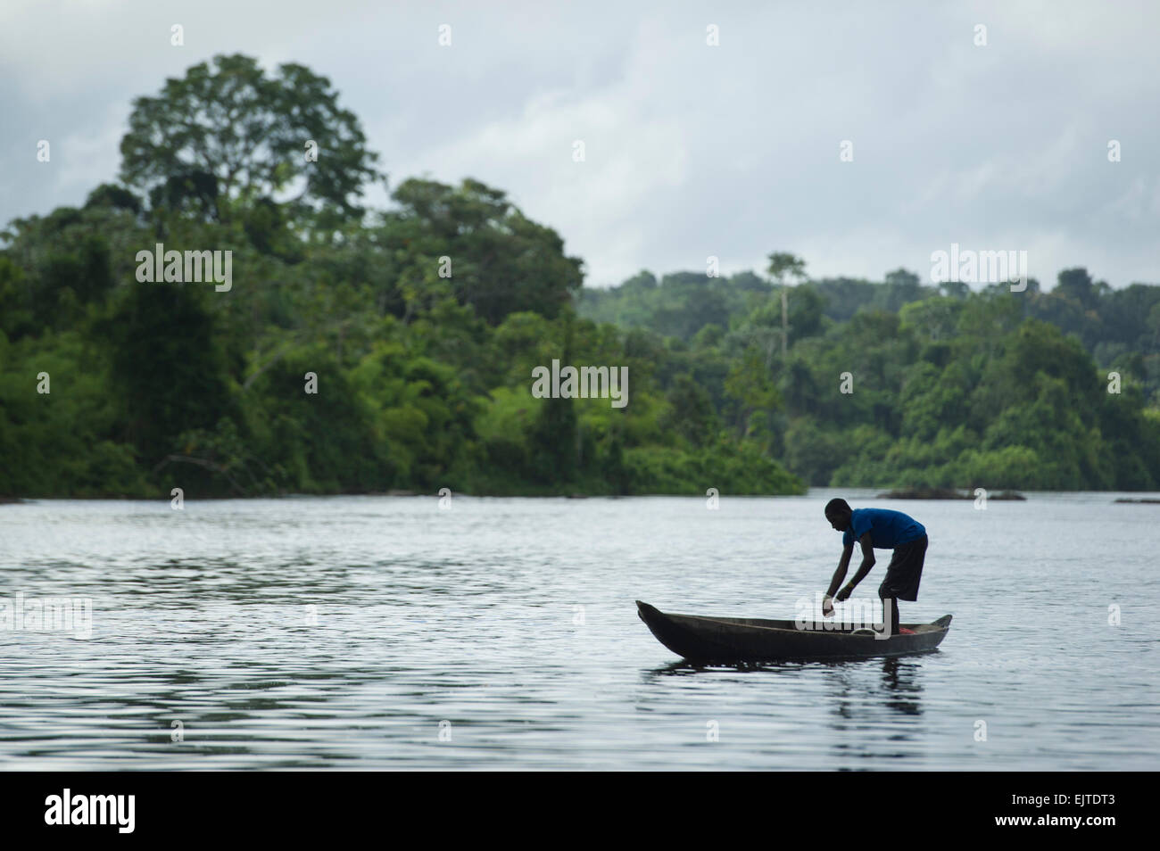 Kastanienbrauner junge Angeln von einem Boot auf dem oberen Suriname River, neue Aurora, Suriname Stockfoto