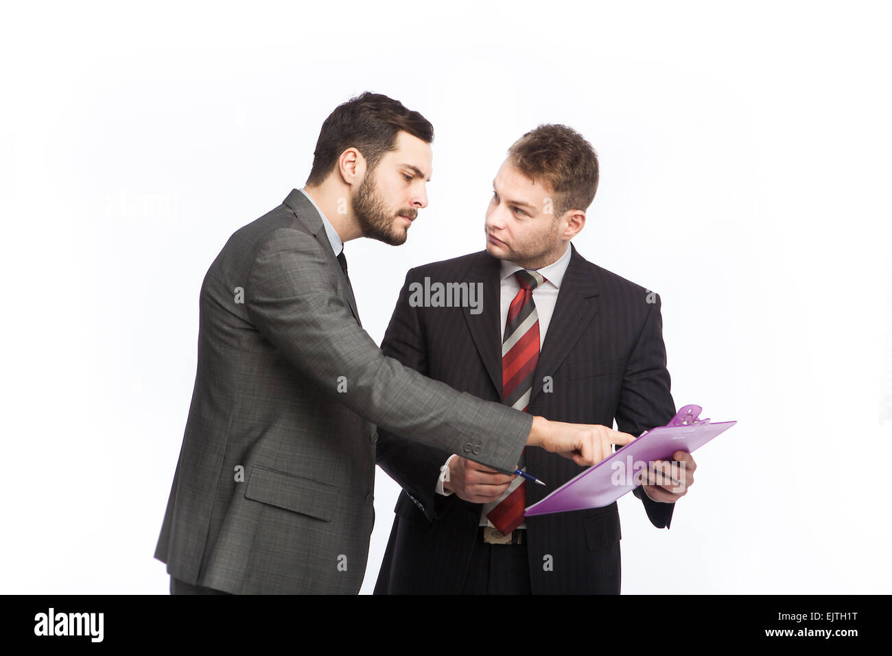 Geschäftsmann weist eine Zwischenablage in Händen von seinen Kollegen auf weiß Stockfoto