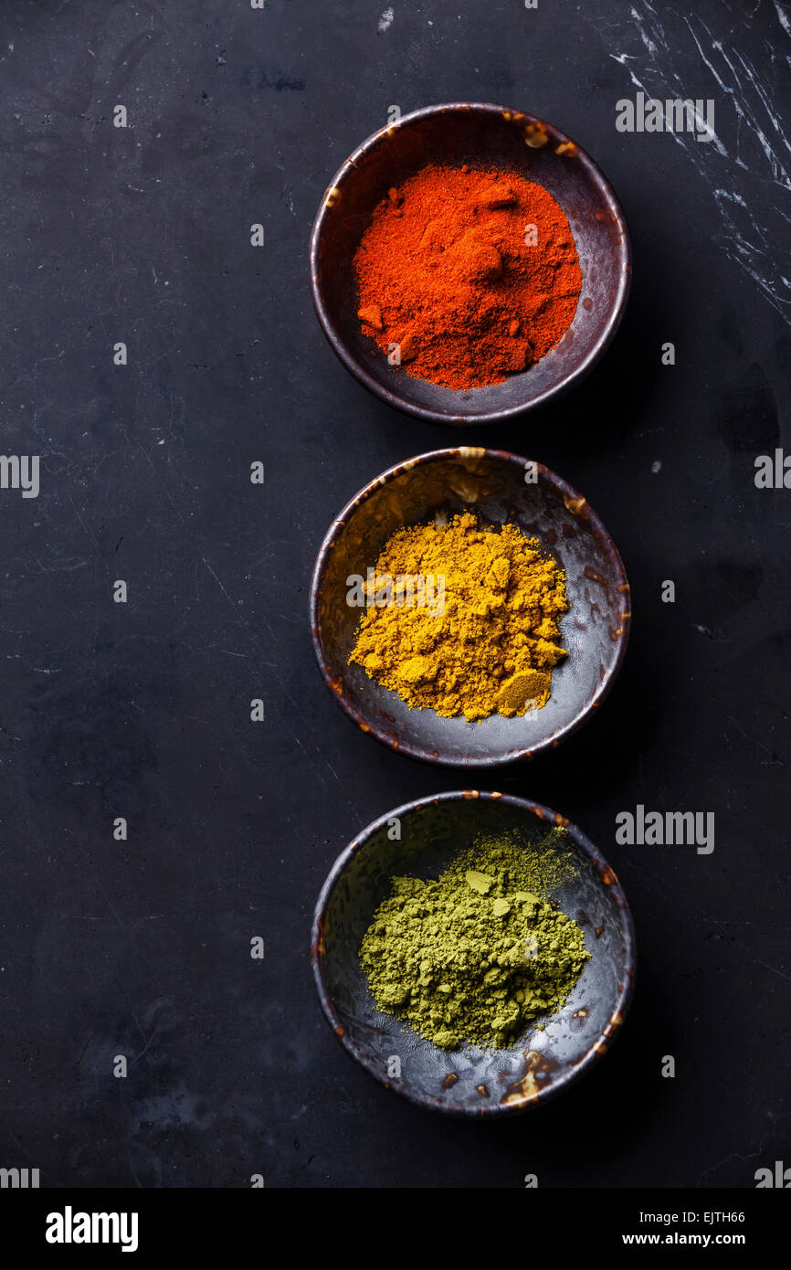 Gewürze-Curry, Paprika, Matcha-Tee auf dunklem Marmor Stockfoto