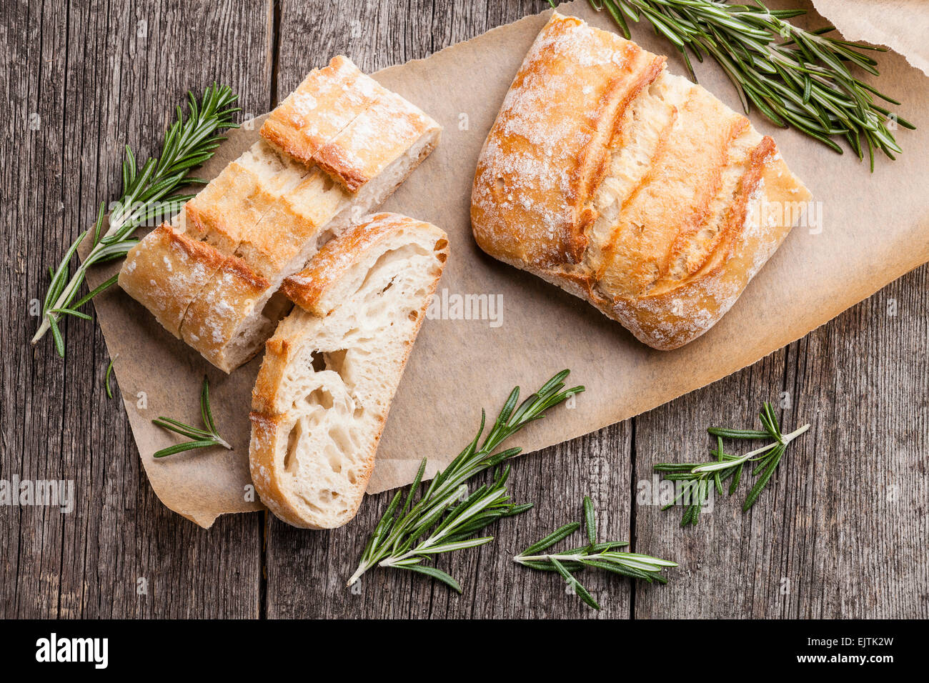 Geschnittenem Brot Ciabatta und Rosmarin auf hölzernen Hintergrund Stockfoto