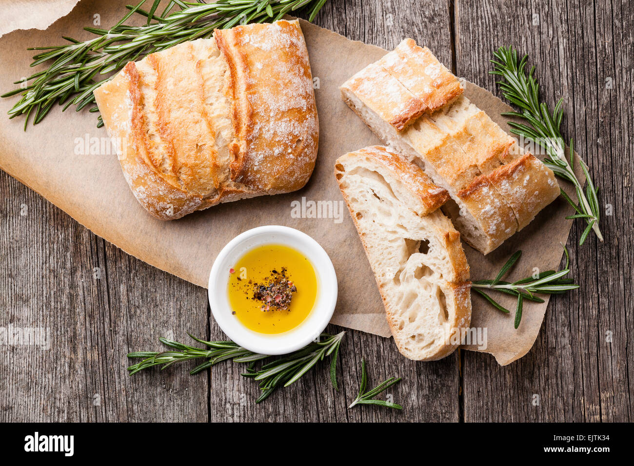 Geschnittenem Brot Ciabatta und Olivenöl extra vergine auf hölzernen Hintergrund Stockfoto