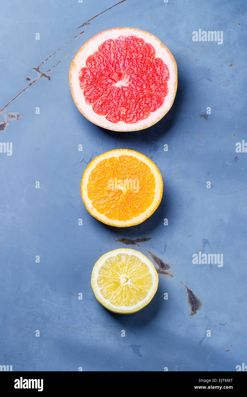 In Scheiben geschnitten Zitrusfrüchten Zitronen-, Orangen- und Grapefruitsaft über blaue Metalloberfläche. Ansicht von oben. Stockfoto