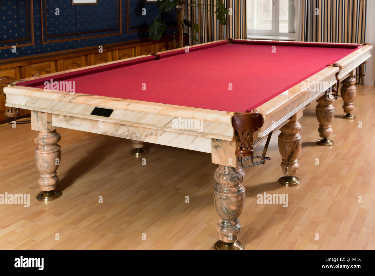 Luxuriöses Marmor-Tisch mit einem roten Tuch für Billard in Zimmer mit Fenster Stockfoto