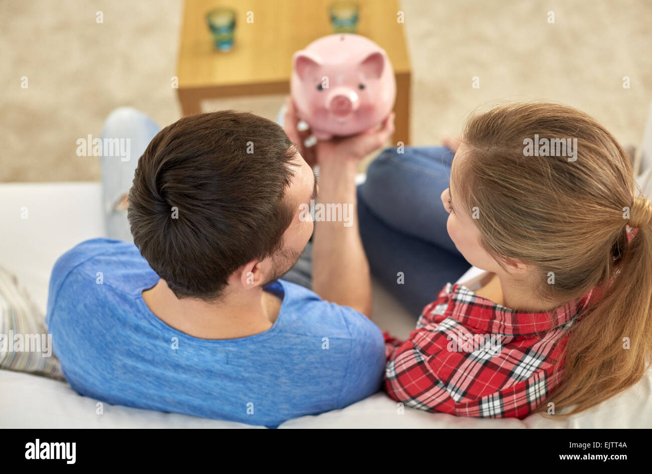 Nahaufnahme eines Paares mit Sparschwein auf sofa Stockfoto