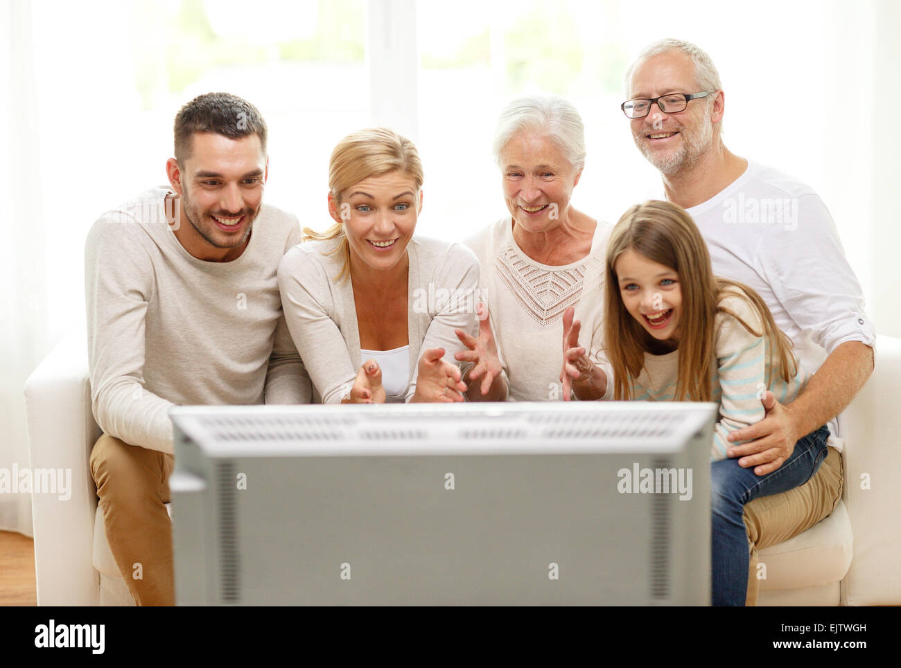 glückliche Familie vor dem Fernseher zu Hause Stockfoto