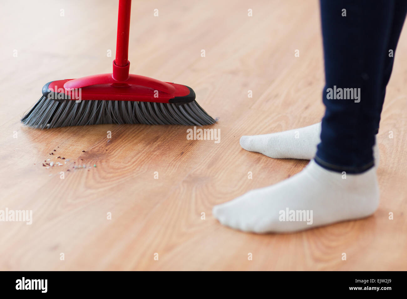 Nahaufnahme von Frau Beine mit Besen fegt Stock Stockfoto