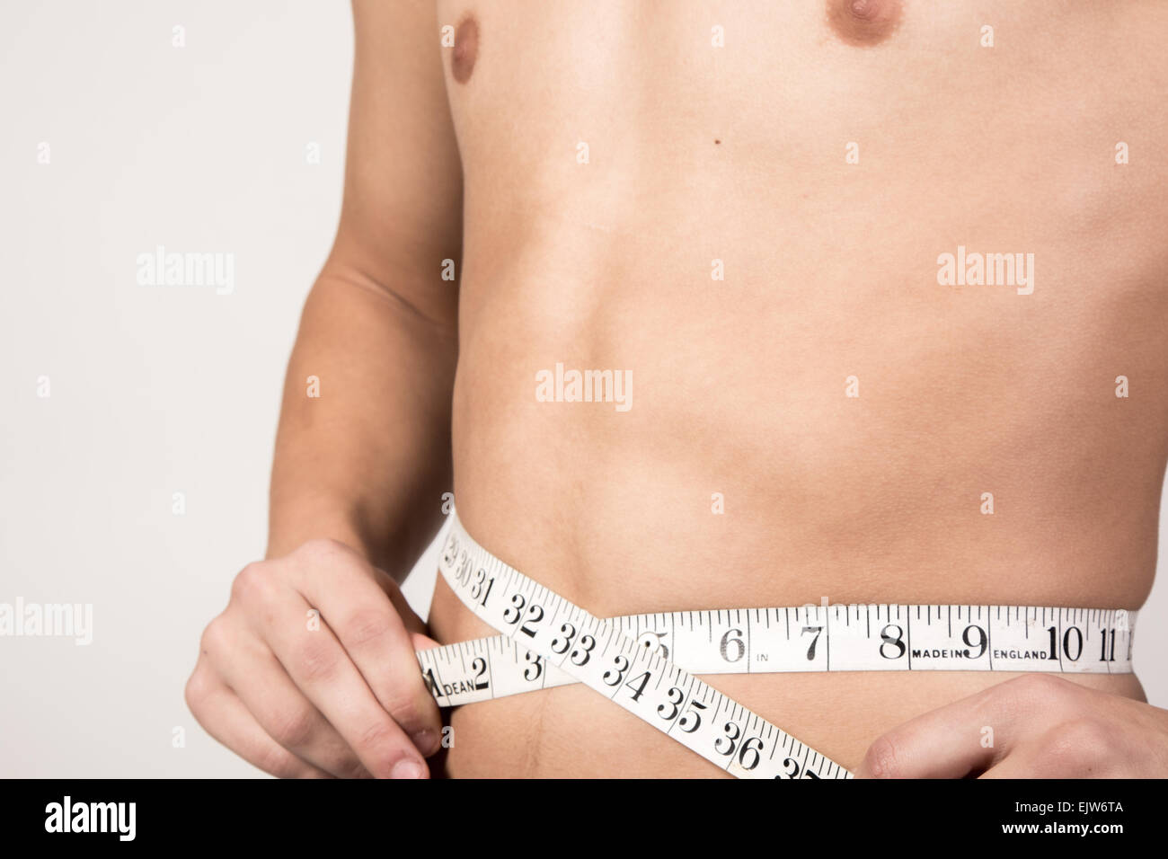 Weiße Teenager seinen Bauch zu messen. Studio gedreht Stockfoto