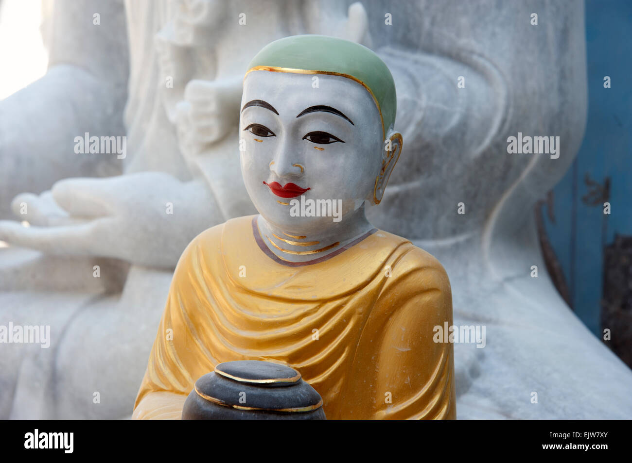 Bunt bemalte Buddhastatue gegen Teil von weißem Marmor Buddha-Statue Mandalay Myanmar Burma Stockfoto