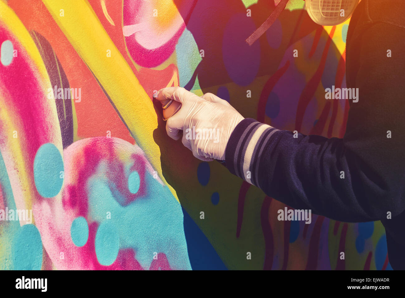 Erwachsene männliche Graffiti Künstler malen, sprühen die Wand, Urban Outdoor Street Kunstkonzept, getönten Bild mit Tiefenschärfe Stockfoto